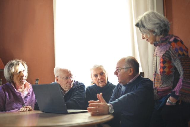 Senior citizens discussing about various financial options for monthly income.